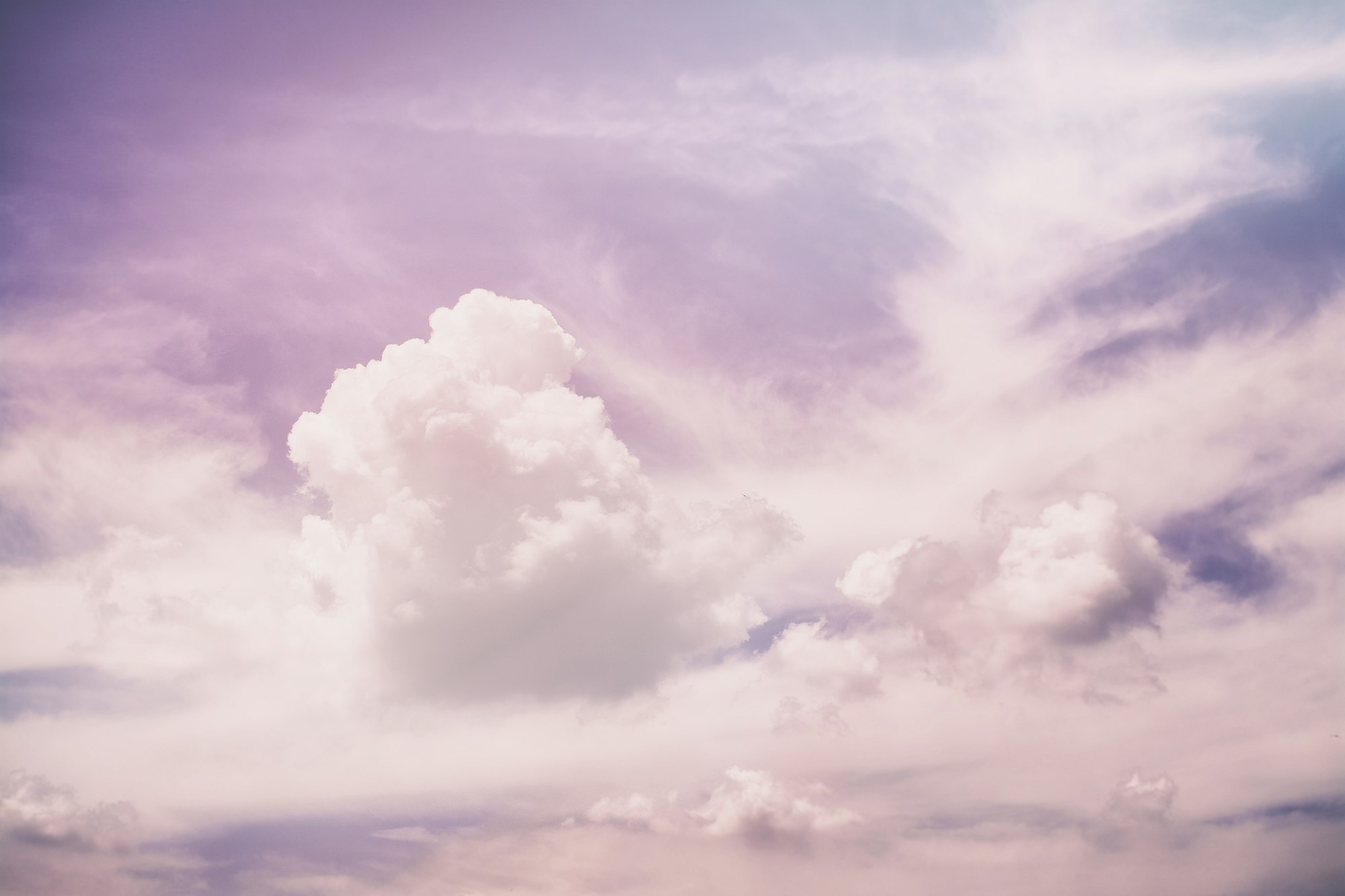 A lone cumulus cloud in a soft pastel sky