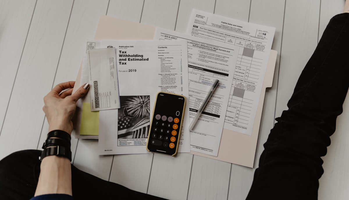 A calculator resting on itemized financial paperwork, used to total pre-launch startup costs before a Section 195 election