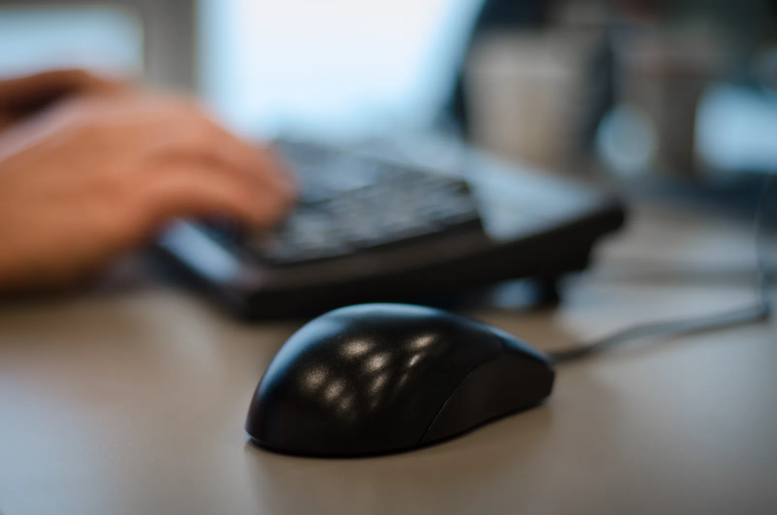 Accountant typing at a desk keyboard while working through a month-end close